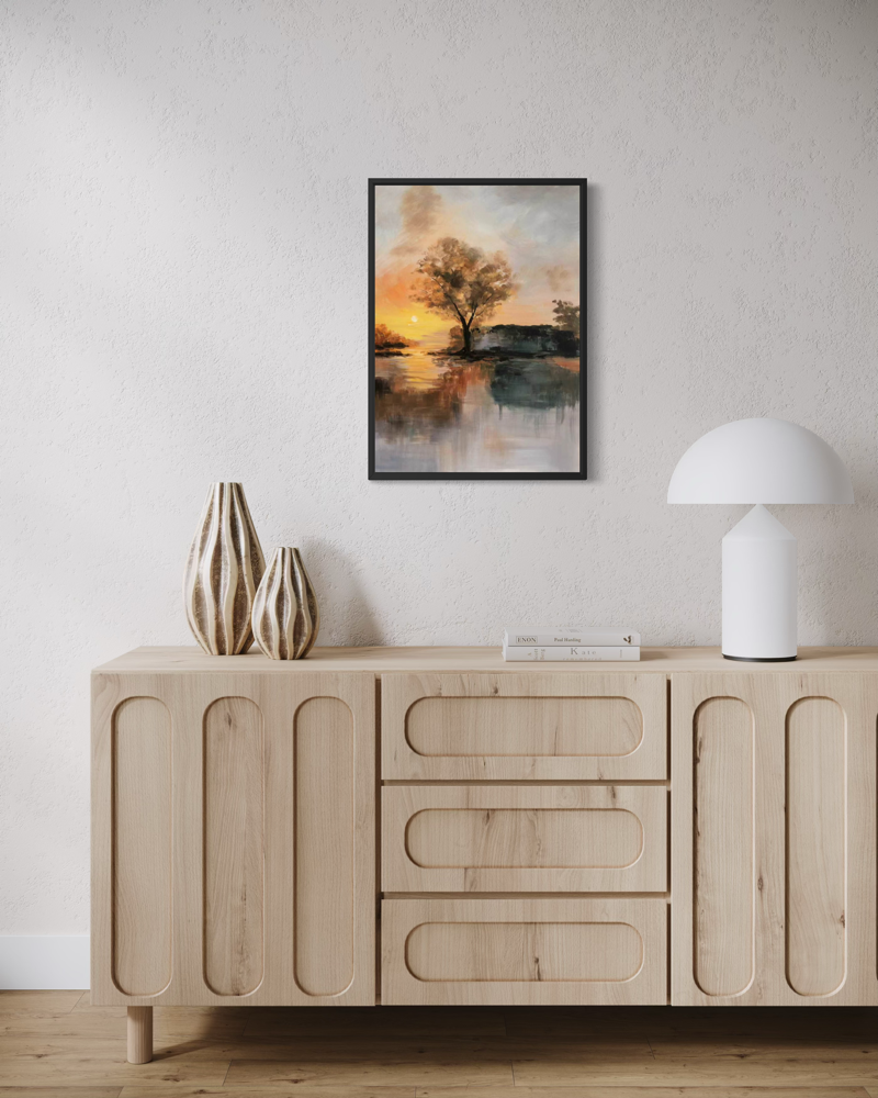 Käsinmaalattu That Evening -taulu 50x70 cm mustalla kehyslistalla, lämpimissä kullan, oranssin ja maanläheisissä sävyissä, aiheena puu veden äärellä ilta-auringossa.